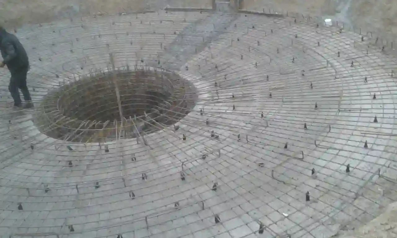 Close-up of circular rebar grid and central opening prepared for vertical structure